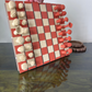 chessboard with red and white pieces on a reflective surface.